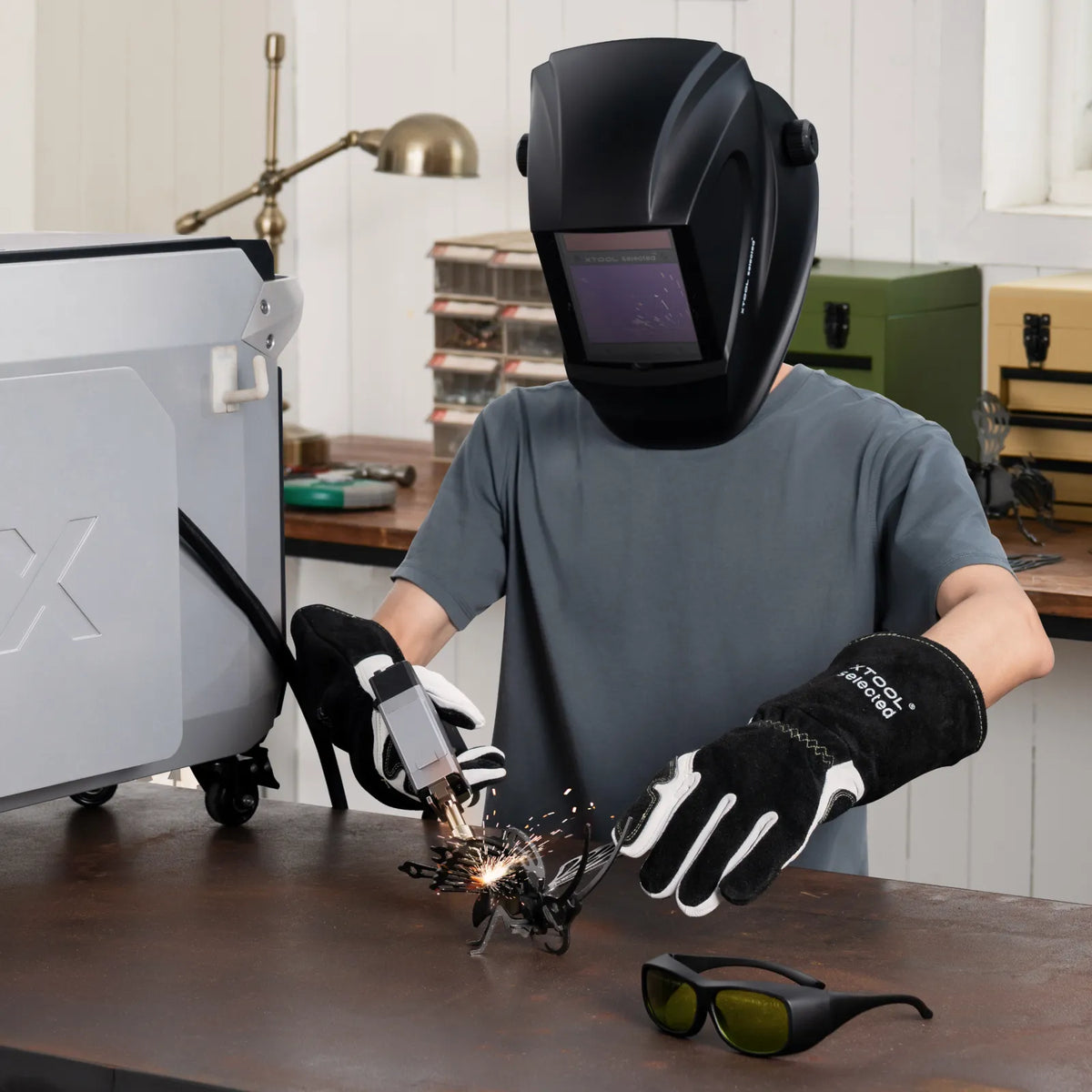 Person welding with protective gear in a workshop setting